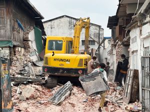 People clear debris from damaged buildings