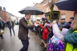 The Prince of Wales shelters from rain under a umbrella whilst meeting members of the public who are holding up a Aston Villa FC scarf during a visit to the Hanging Gardens. Photo: Ben Birchall/PA Wire