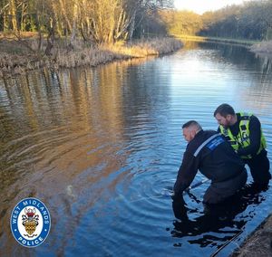 Officers pull an abandoned off-road bike from the canal