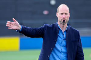 The Prince of Wales blows the referee's whistle during a mini football game