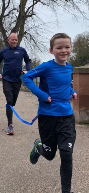 Carter Chatting runs through the finish line on Sunday followed by his dad Matthew.