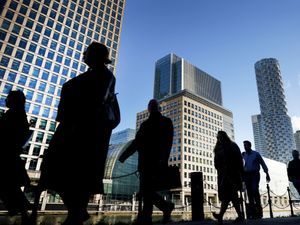 Silhouettes of people walking in front of high-rise buildings