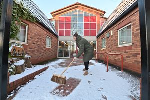 Snow in Perton. Tara gets the Perton Library entrance ready.