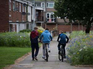 Some boys in the street, two on bikes