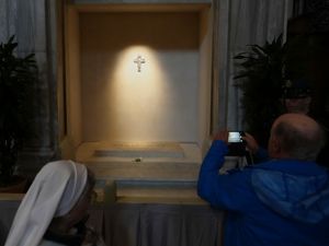 A visitor takes a photo of the tomb of Pope Francis