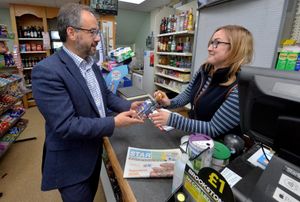 Post office minister Paul Scully buys a Shropshire Star and a bottle of Wrekin gin during his visit to Waters Upton post office, where he was served by Katie Baker