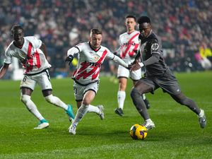 Real Madrid and Rayo Vallecano players challenging for the ball