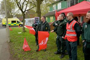 Members of the Unite Union watch an ambulance come into the hub