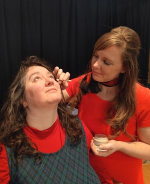 The Revlon Girl (Amber Harris R) shows Marilyn (Katy Gulliver) how to make the best of her tired eyes