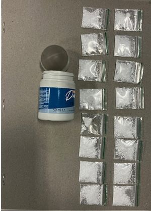 A total of 16 bags of cocaine were discovered concealed in a tub along with cash and multiple mobile phones