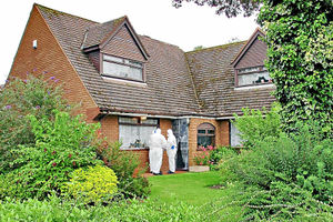 Officers scour the rear of Miss Mottershead's house in in Tettenhall, Wolverhampton