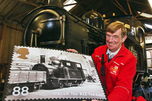 Welshpool postman Nick Thomas with an 88p landscape stamp of steam locomotive The Earl No822