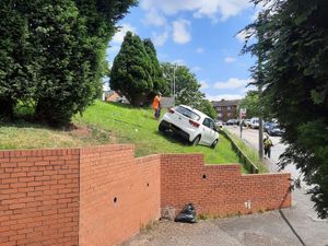 Supporting image for story: Road shut for hours after car rolls down embankment and ends up 'balanced precariously'