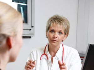 B63921 Female doctor in a hospital talks to a patient