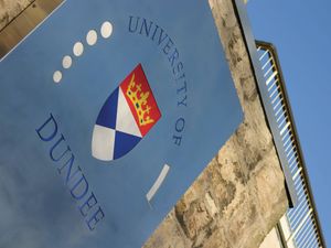 University of Dundee sign in front of a building, under a blue sky