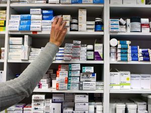 A pharmacist stocking shelves