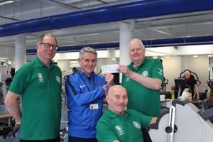 Robin Shields, left, and John Corser, right, present the cheque to Russell Tipson as Terry Astley demonstrates how the exercise machines are helping his rehabilitation

 