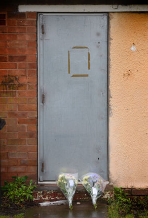 Flowers rest at the front door of the bungalow
