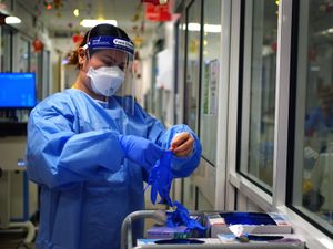 A nurse putting on protective clothing in the COVID-19 pandemic