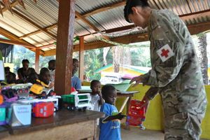 Captain Adrienne Doyle hands out presents to orphans in Sierra Leone