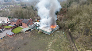 Large plumes of smoke and vivid flames could be seen coming out of the roof of the workshop. Photo: Ross Taylor