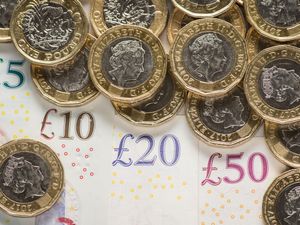 UK five pound, ten pound, twenty pound and fifty pound notes with one pound coins