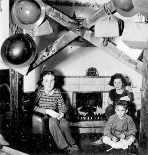 'Christmas 1940, ceiling strutted up.' This was taken at the home of the Roden family in High Street, Bridgnorth, and the oak beams are to try to stop the place collapsing on them if there was a bomb hit. Left is Sylvia Roden (who became Mrs Sylvia Stubbs) and right is her brother Roger Roden. The girl on the right is Lindsay Beresford, an evacuee who was a headmistress's daughter from Derby. This is one of a large number of wartime photos of Bridgnorth and the surrounding area which was taken by Walter Roden. The image is courtesy of his grandson Jonathan Stubbs.