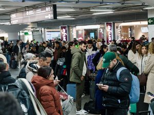 Passengers wait in the hall of Madrid train station on Sunday (Carlos Lujan/AP)