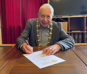 Mayor David Cooper signing the pledge