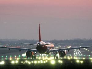 EasyJet plane at the end of an illuminated runway, about to take off