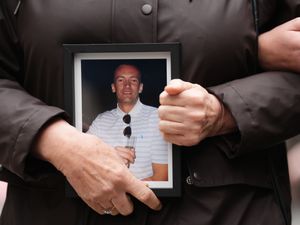 A framed photo of Calum Inglis is held by his mother