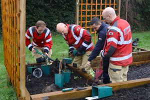 Firefighters taking part in planting a variety of flowers, shrubs and herbs in the newly constructed raised beds