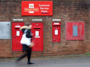 A person walking past a Royal Mail sorting office