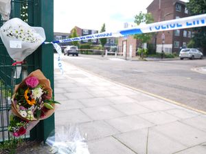 Flowers near to the scene in Stellman Close in Hackney, London, where a 15-year-old boy died after being stabbed