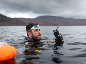 Ultra-swimmer Ross Edgley submerged underwater with his head above the surface wearing goggles