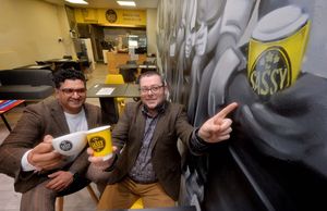 Rajesh Brigue and Adam Bright show off the inside of the new shop, complete with wall mural