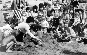 This photo from August 18, 1975, shows a trip to the Blackpool beach for Bloxwich Memorial Club. The caption reads: 'Mrs Janet Allen of Valley Road, Bloxwich, trying to make a sand castle, but every time down came the demolishing spade of John Jones, also of Valley Road, Bloxwich.'