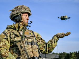 A soldier launches a drone on exercise on Salisbury Plain