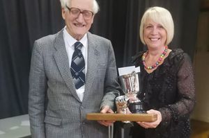 Ionwen Davies, conductor of Builth Wells Ladies Choir, receiving the cup for winning the choir competition, from Hywel Davies, Chairman of Llanwrtyd Eisteddfod. Image by Elin Mabbutt