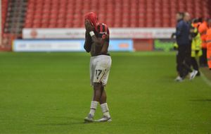 Courtney Clarke hides his head in his shirt after Walsall's defeat.
