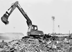 Demolition at Watling Street, Wellington, in January 1978. The caption reads: 'Demolition work in progress at Watling Street, Wellington. Buildings by Telford United Football Club are being pulled down to improve approaches to the club and the local amenities.' n demolition. Bucks Head football ground. Digger. The machine is operated by Anslow's of Telford and has the name Mustang on it, which may be the make. The picture was taken on January 23, 1978 and the print has the Shropshire Star copyright stamp. The photographer was Bill Bishton. Library code: Wellington nostalgia 2021.