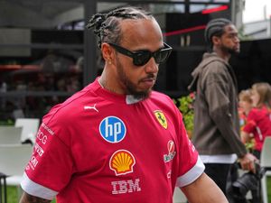 Ferrari driver Lewis Hamilton walks through the paddock ahead of the Australian Formula One Grand Prix at Albert Park