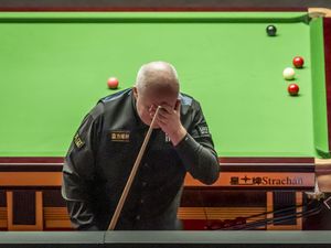 John Higgins reacts with his hand over his face