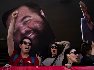 Demonstrators hold photos depicting the faces of Israeli hostages