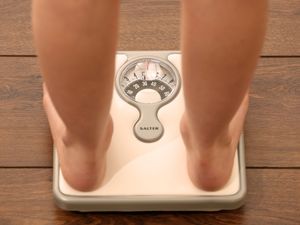 A person weighing themselves on scales