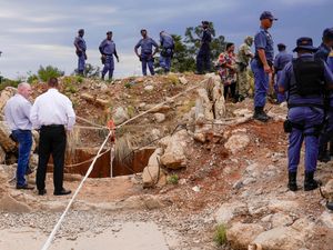 Police and private security officers near an opening to a gold mine in Stilfontein, South Africa, where hundreds of illegal miners are trapped