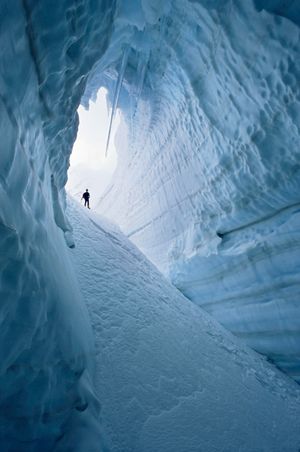 Climber standing at mouth of crevasse