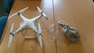 One of the drones and a bag of drugs which was seized after an attempt to smuggle the drugs into a prison