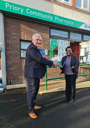 Councillor Patrick Harley, leader of the council, hands over some testing kits to Olutayo Arikwe, pharmacist at Priory Pharmacy