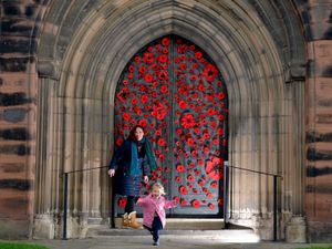 Supporting image for story: Shrewsbury 'yarn bombers' cover abbey’s ancient doors with poppies in tribute